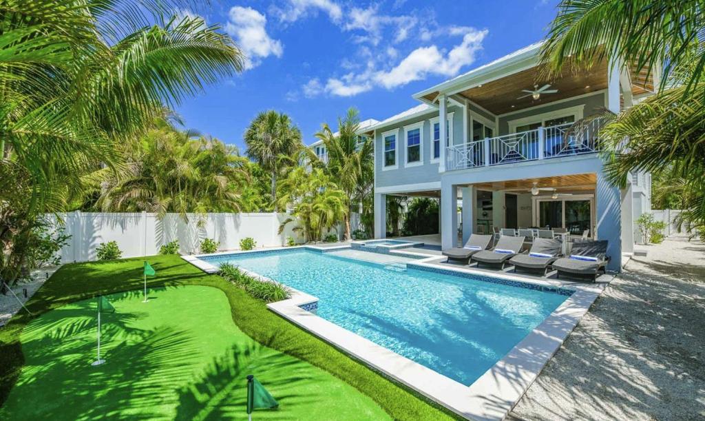 uma casa com piscina e uma villa em Anna Maria Beach House, 5 beds 6,5 baths, roof-top deck and pet-friendly! em Anna Maria