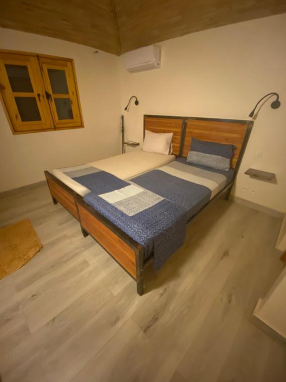 un grande letto in una camera con pavimento in legno di Magnifica villa con giardino e piscina a Nianing