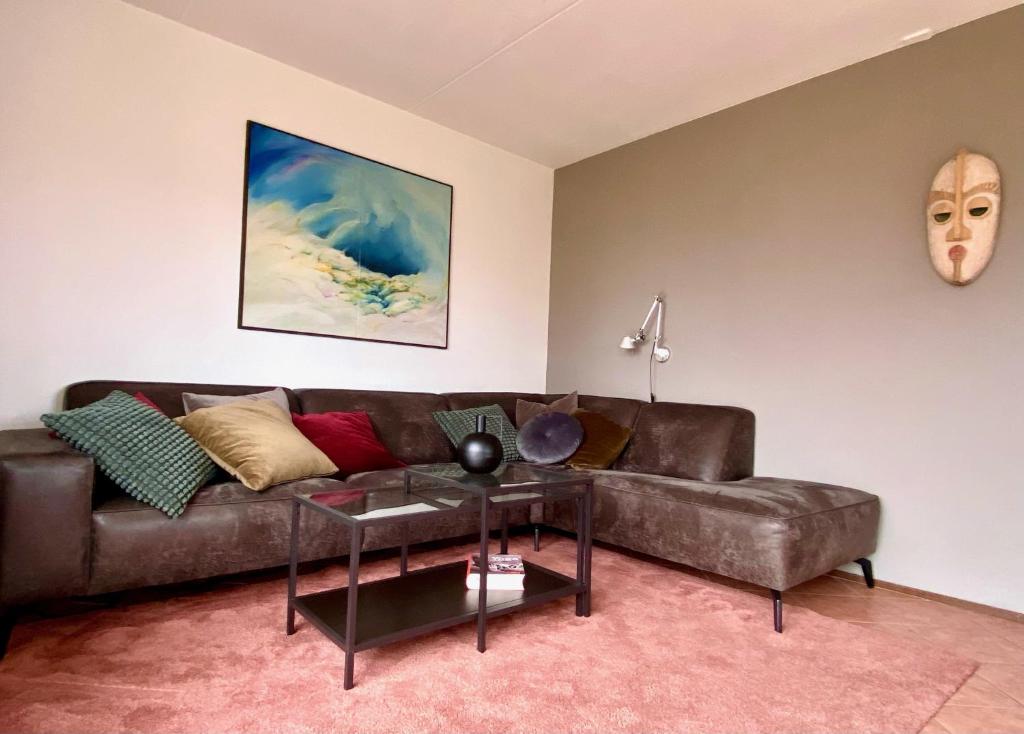 a living room with a brown couch and a table at Kustverhuur, Park Scheldeveste Zwin 010 in Breskens