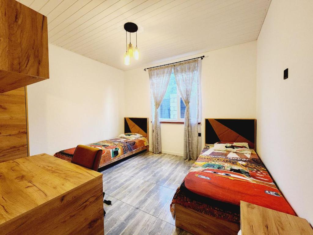 two beds in a room with a window at Guest house in Lankaran