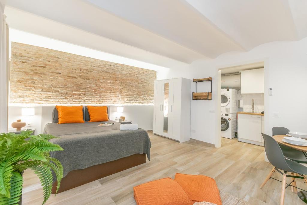 a bedroom with a bed and a brick wall at Carretes 1 in Barcelona