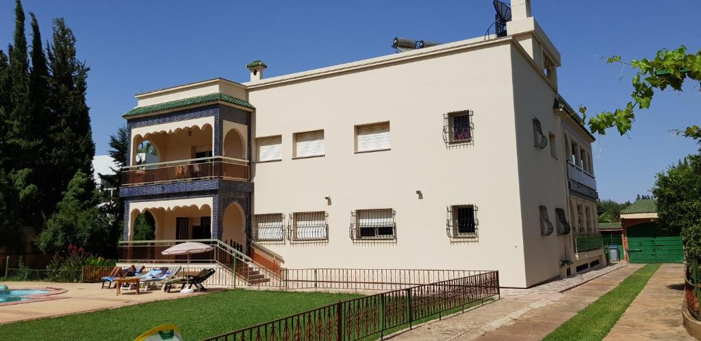 een groot wit gebouw met een patio en een tuin bij VILLA PLAISANCE in Meknès