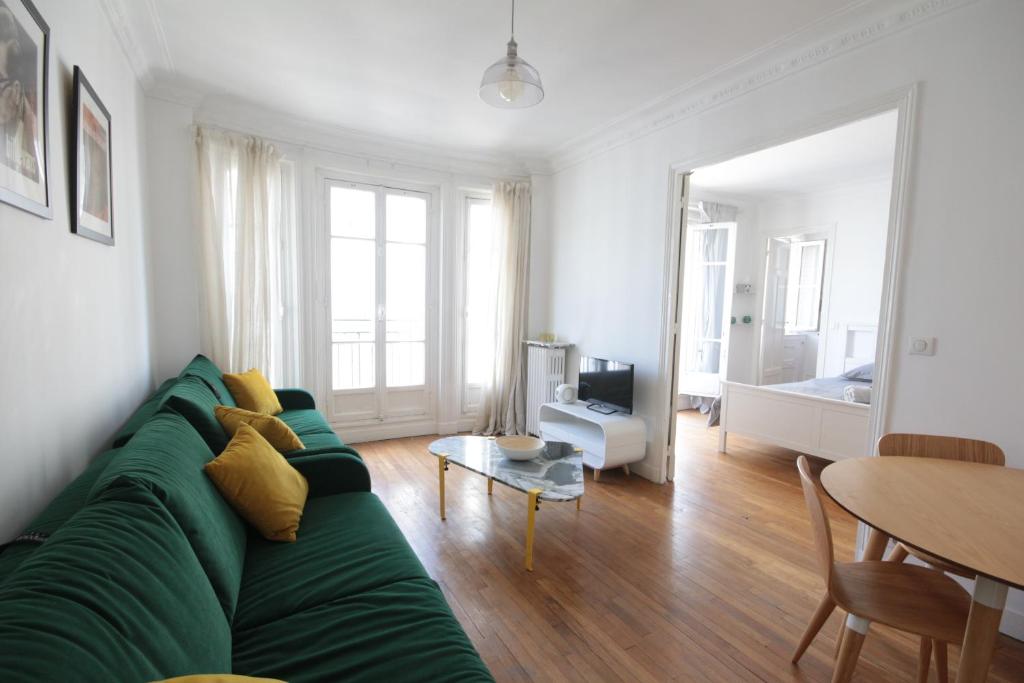 un salon avec un canapé vert et une table dans l'établissement Spacieux 2 Pièces Montmartre, à Paris