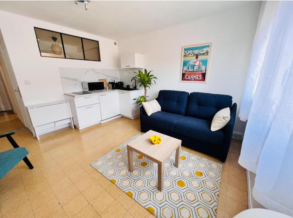 un salon avec un canapé bleu et une table dans l'établissement 2 pièces, 8mn à pied de la croisette/plage, à Cannes