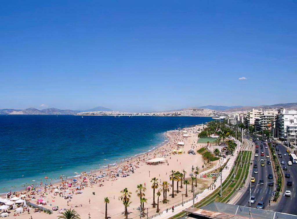 una playa con mucha gente y el océano en Lux Modern Apt Ανακαινισμένο διαμέρισμα 150m από την πλαζ 'ΈΔΕΜ', en Atenas