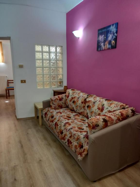 - un canapé dans un salon avec un mur violet dans l'établissement Casa turistica Santa Lucia 25, à Regalbuto