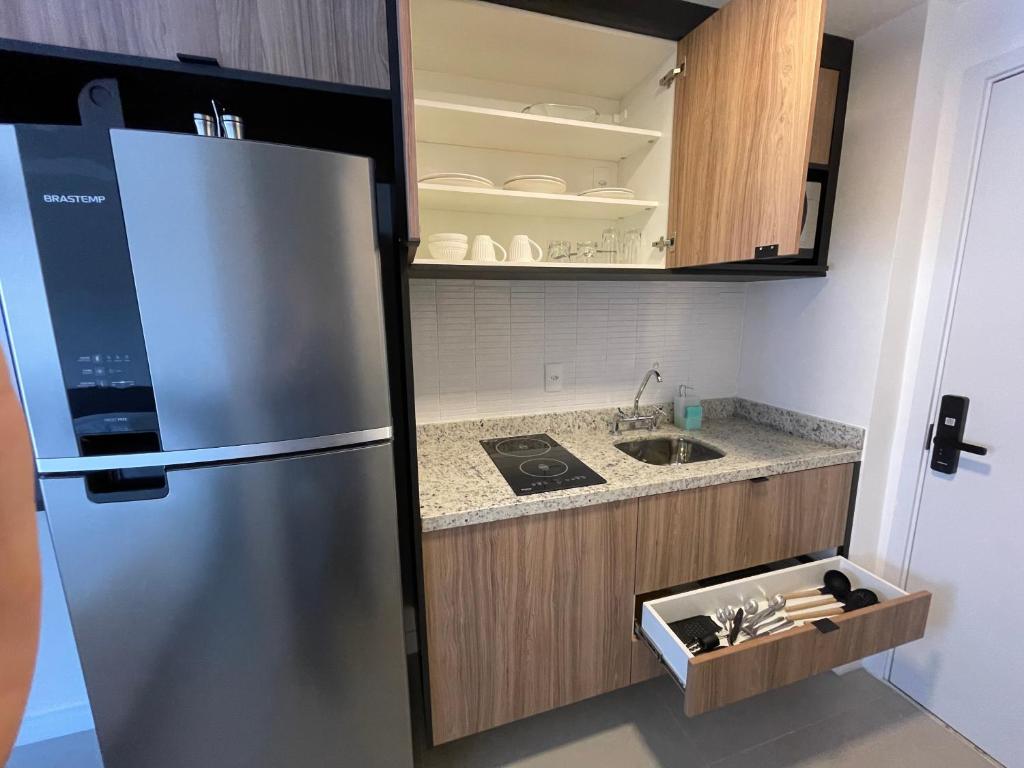 a kitchen with a refrigerator and a sink at Studio Luxo Expo SP Itaú in São Paulo