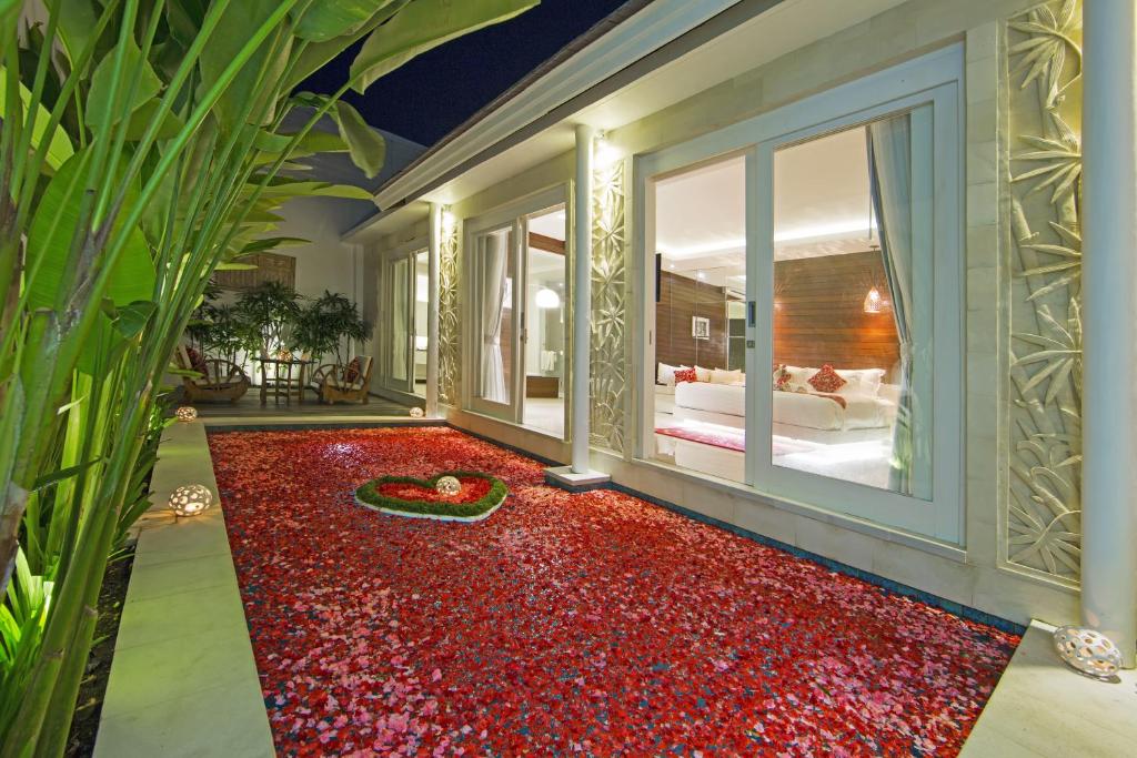 a room with a red carpet in front of a bed at Bajra Bali Villa Seminyak in Seminyak