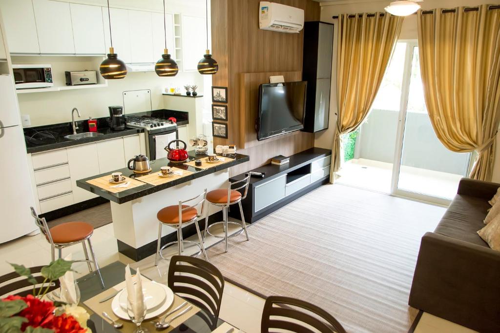 a kitchen and living room with a table and chairs at APTO ACONCHEGANTE proximo ao centro in Foz do Iguaçu