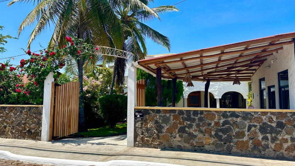 a house with a wooden gate and a fence at Hostal Sueños Silvestres in Puerto Ayora