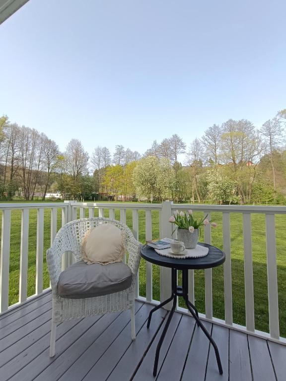 a table and a chair on a deck with a table at Mobilheim Bukovina in Mnichovo Hradiště