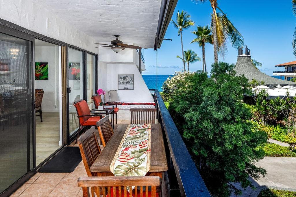 un porche con mesa, sillas y el océano en Casa De Emdeko 211, en Kailua-Kona