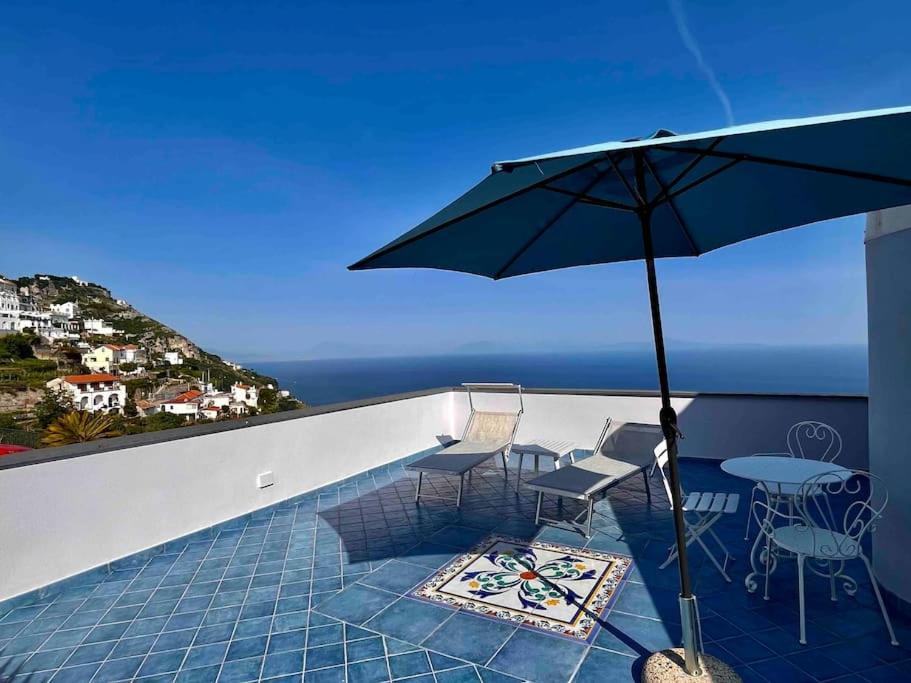 een patio met een tafel en stoelen en een parasol bij La casa delle stelle in Castelvetere sul Calore