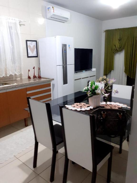 Il comprend une cuisine équipée d'une table, de chaises et d'un réfrigérateur. dans l'établissement Apartamento Balneário rincão, à Aliatar