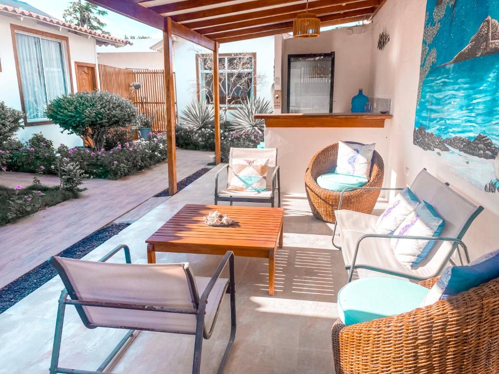 eine Terrasse mit Stühlen, einem Holztisch und einem Tisch am Tisch in der Unterkunft Hotel Coral Blanco with high speed internet Starlink in Puerto Villamil