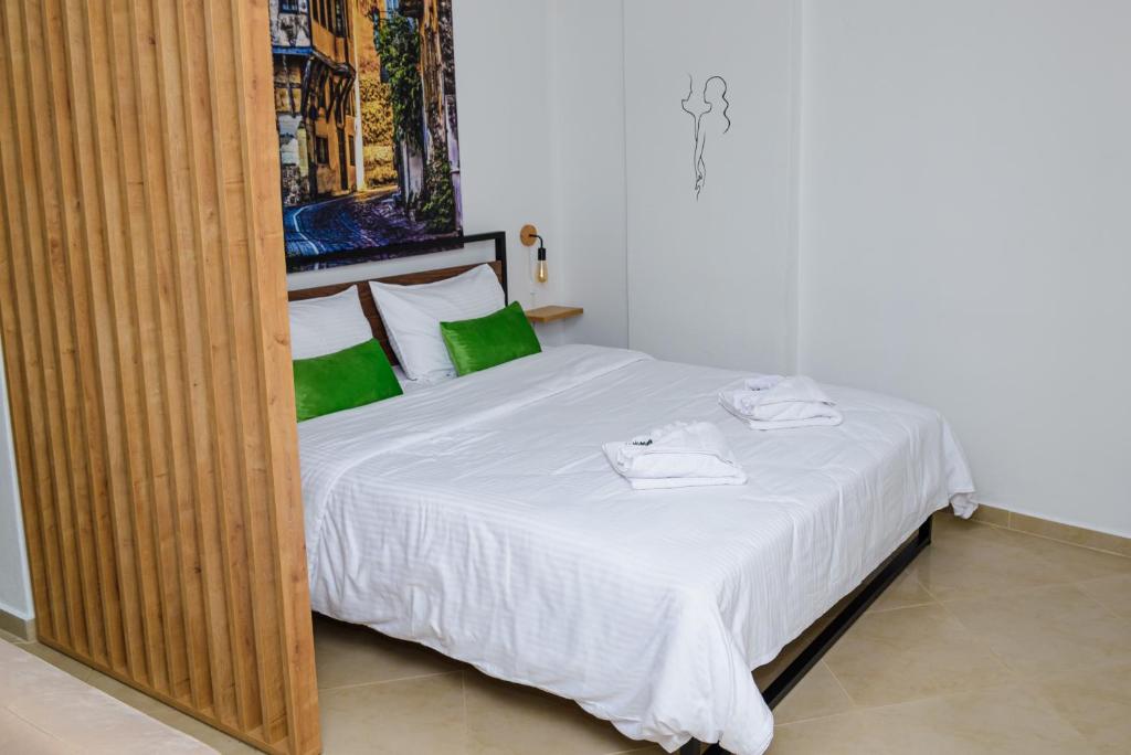 sypialnia z białym łóżkiem z zielonymi poduszkami w obiekcie Emi's House w mieście Ksanti