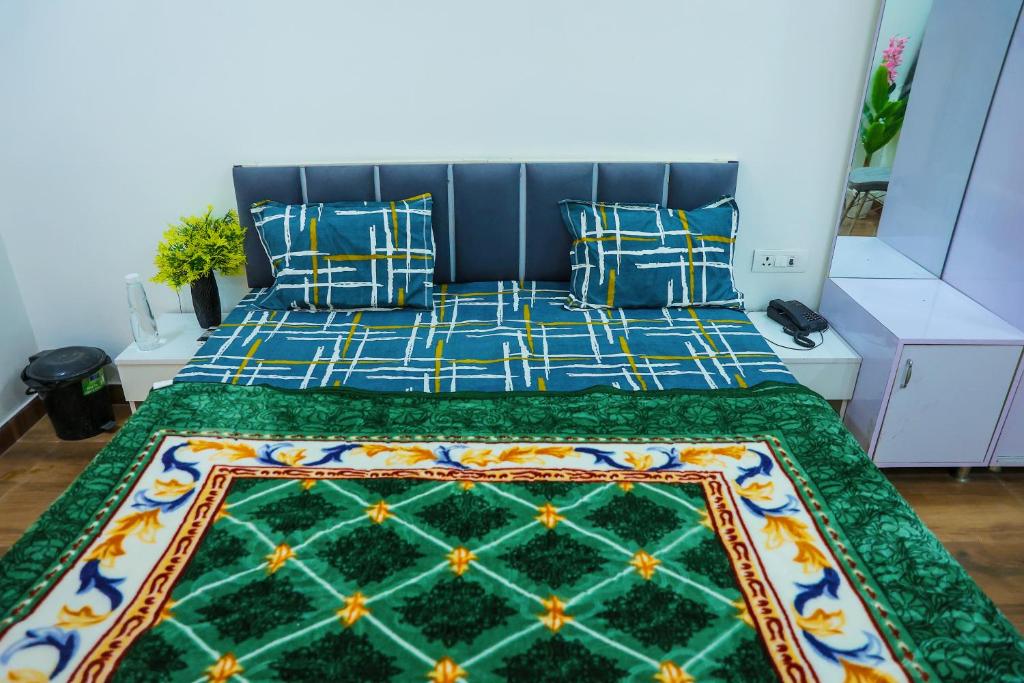 1 dormitorio con 1 cama con colcha colorida en Agrah Stay - Kasa Lusso Stay en Faridabad