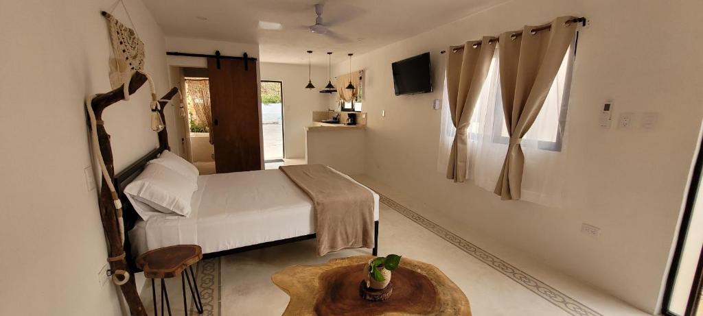 Un dormitorio con una cama y una mesa. en Pakáal Muliix - Naranjo en Mérida
