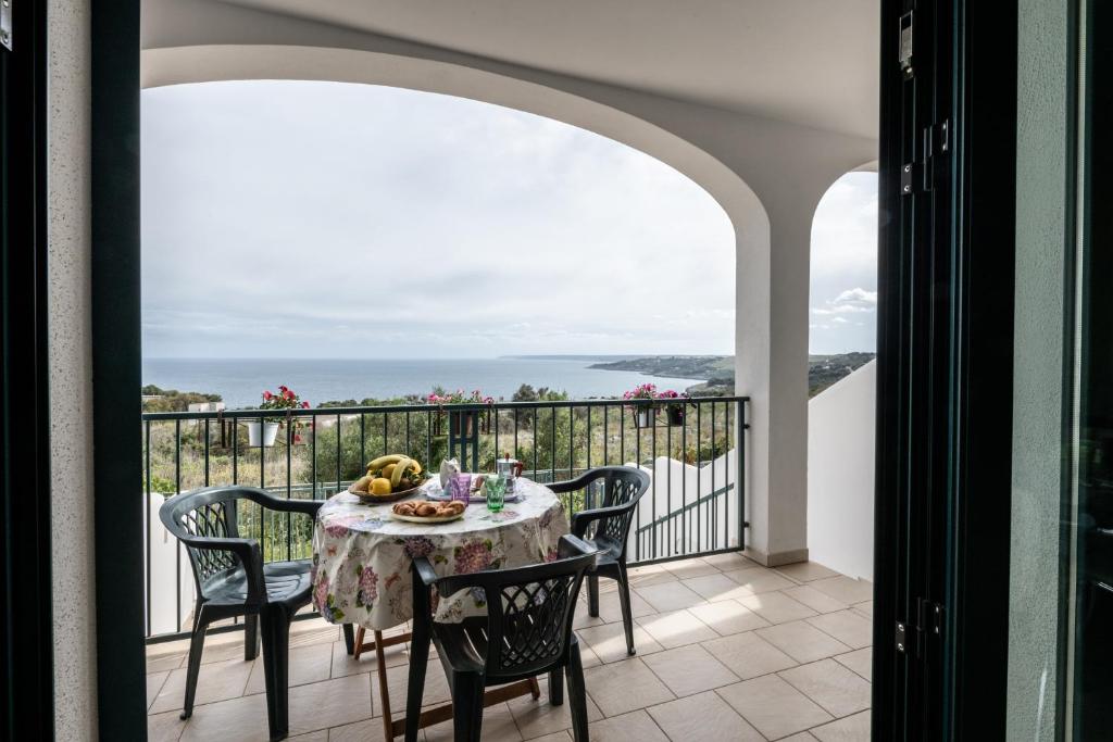 a table and chairs on a balcony with a view of the ocean at L'alba di Santa Cesarea in Santa Cesarea Terme