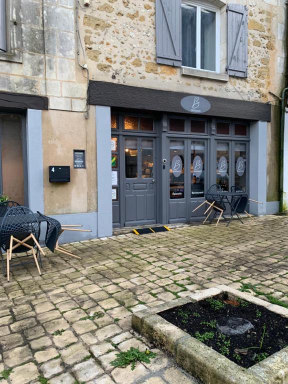 een restaurant met tafels en stoelen voor een gebouw bij Luxury Room in town house in Lunay