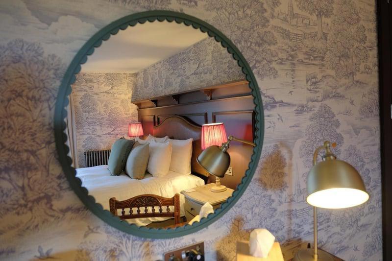 a mirror on a wall with a bed in a room at The Falcon Inn in Scarborough