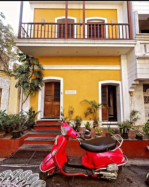 a red scooter parked in front of a house at FRENCH RIVERA Heritage Boutique Villa in Pondicherry