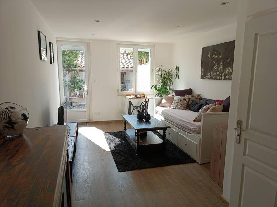 a living room with a couch and a table at Petite maison de ville in Miramont-de-Guyenne
