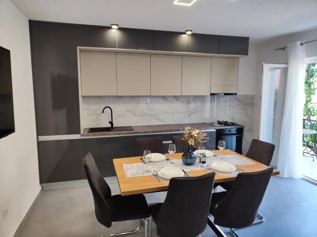 een keuken met een tafel en stoelen in een keuken bij Apartment Ruža in Trogir