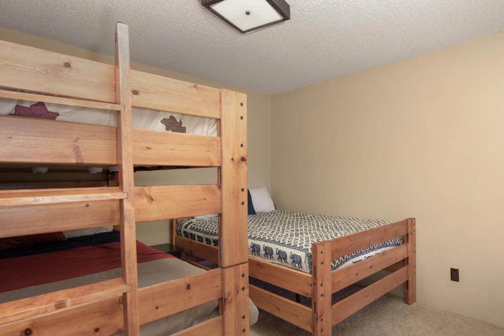 a bedroom with two bunk beds and a ladder at 273 Fallen Rock in Tabernash