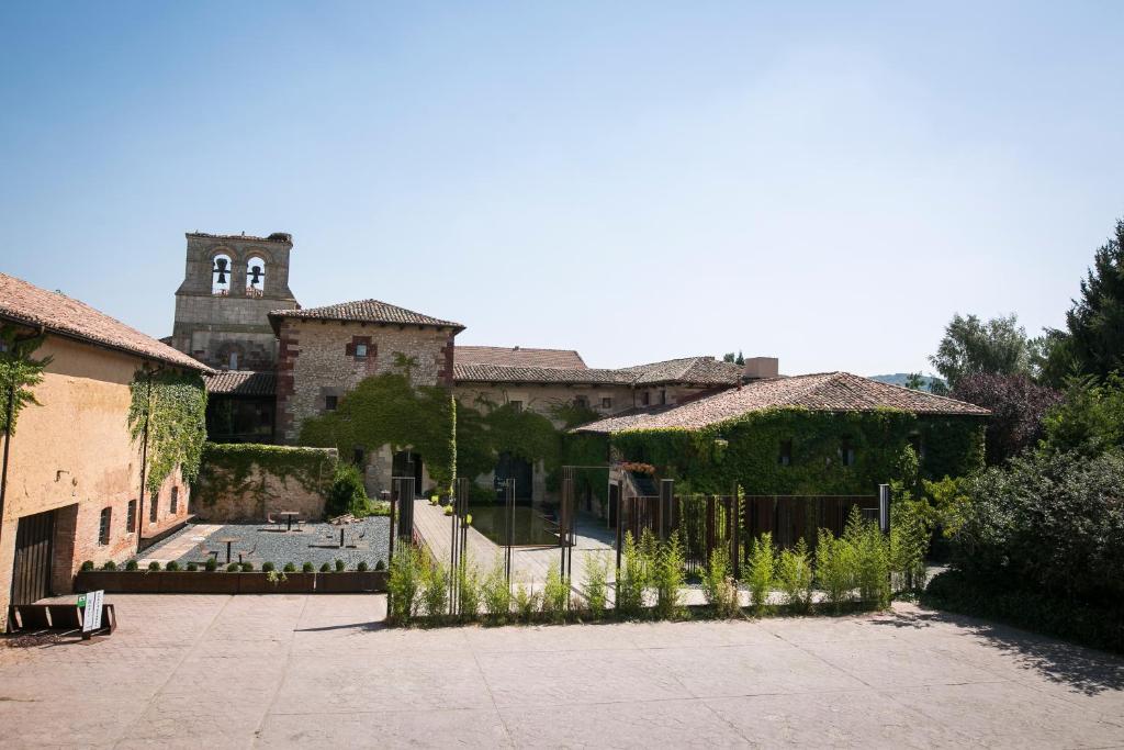 a building with a fence in front of a courtyard at Hotel Boutique El Convento de Mave in Santa María de Mave