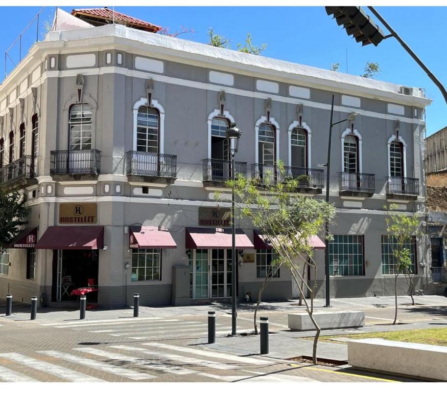 - un bâtiment blanc avec des fenêtres et des balcons dans une rue dans l'établissement Hostel Lit Guadalajara, à Guadalajara