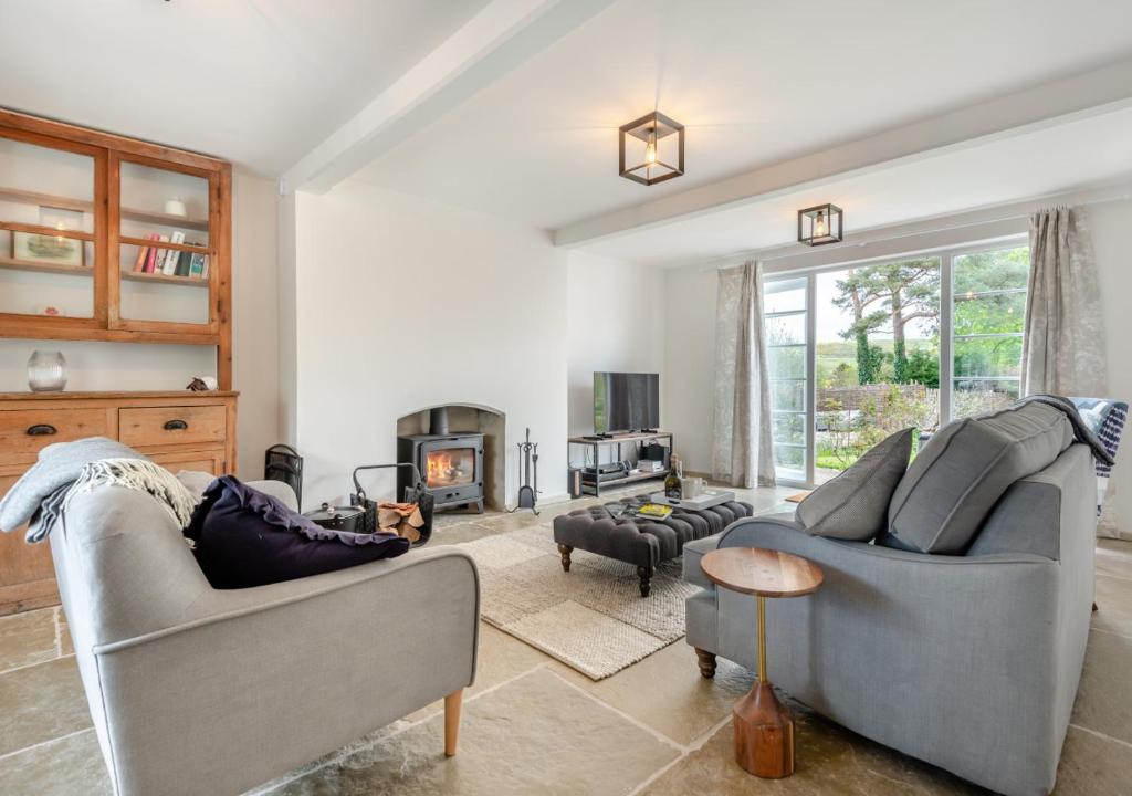 a living room with two couches and a fireplace at Fig Tree Cottage - Corfe Castle in Corfe Castle