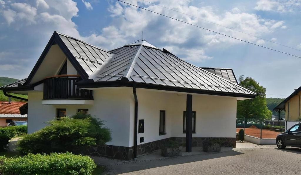 uma casa com um telhado de metal em cima em Apartmánový dom PRAMEŇ em Vinné