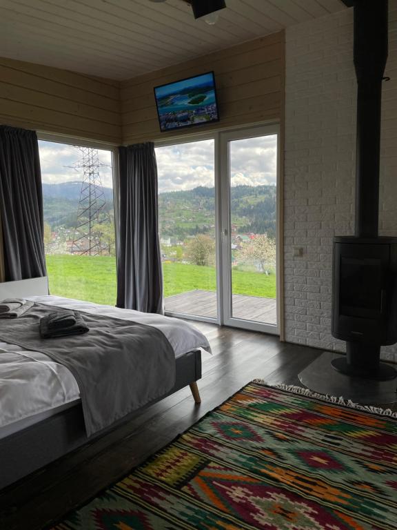 a bedroom with a bed and a flat screen tv at DIDO house in Slavske