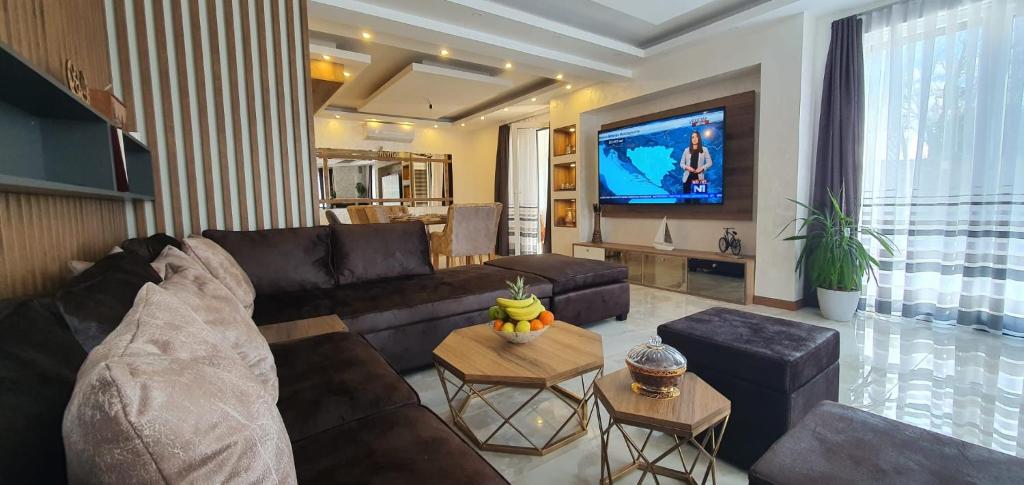 uma sala de estar com um sofá e uma televisão em Villa Otes em Sarajevo