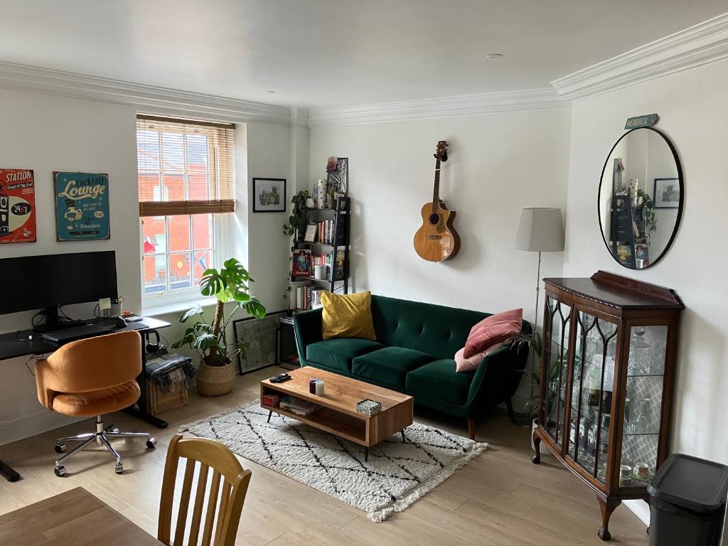 都柏林的住宿－Dorset Street Upper，客厅配有绿色沙发和镜子