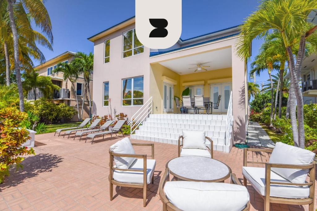 a house with chairs and tables on a patio at Haven House by Brightwild - Luxury Waterfront in Key West