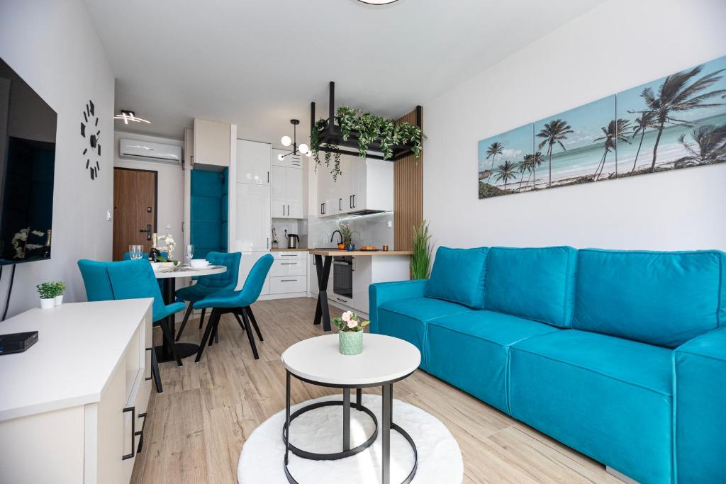 Il comprend un salon avec un canapé bleu et une cuisine. dans l'établissement GIL APARTMENTs 14, à Cracovie