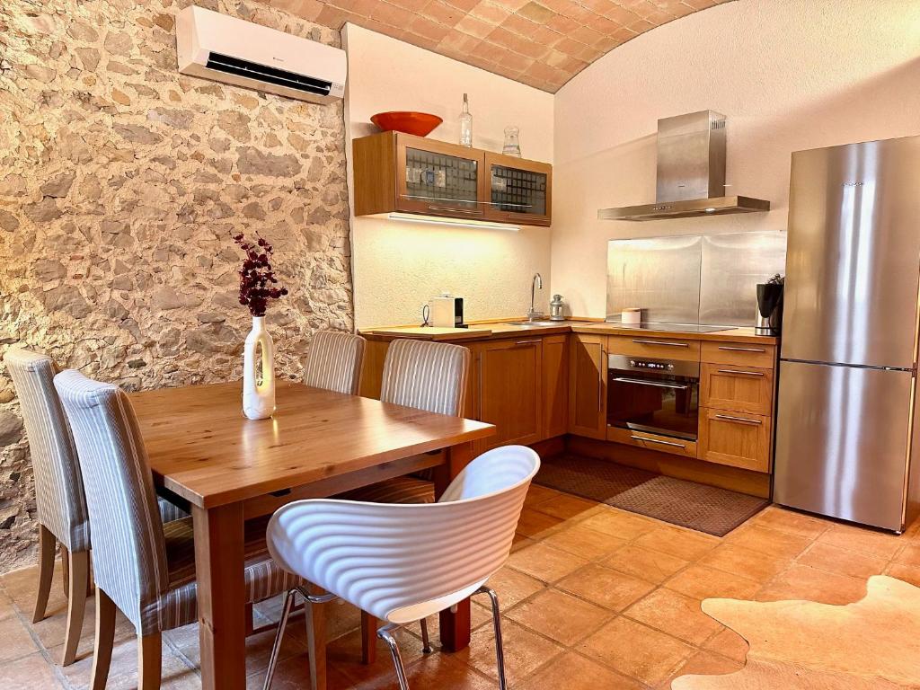 een keuken met een houten tafel en een koelkast bij Ancla in L'Escala