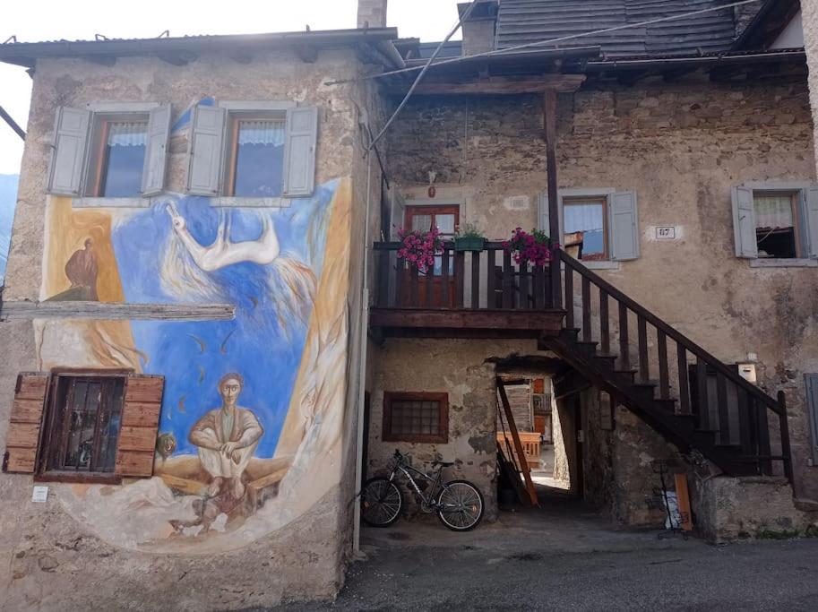 a painting on the side of a building with a staircase at La Ciasa Dell'Emigrante in Cibiana
