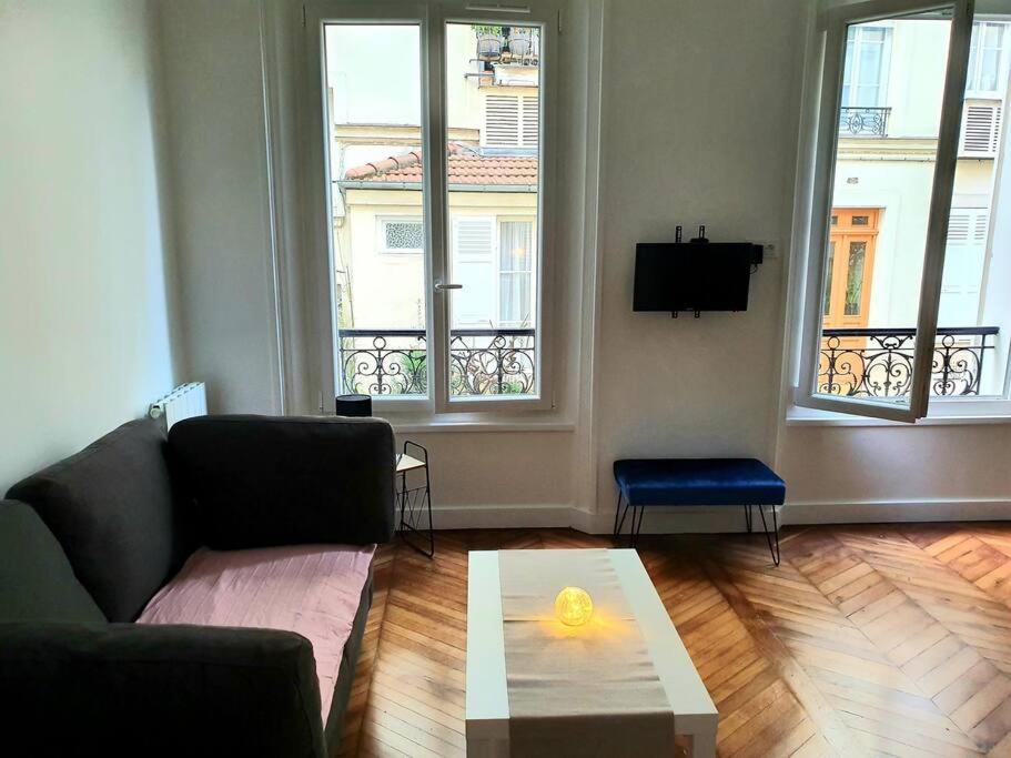 un salon avec un canapé et une table basse dans l'établissement Appartement cosy & cocooning, à Asnières-sur-Seine