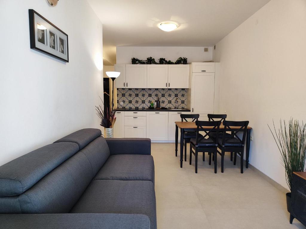 uma sala de estar com um sofá e uma mesa com cadeiras em Apartments Vanda em Rovinj