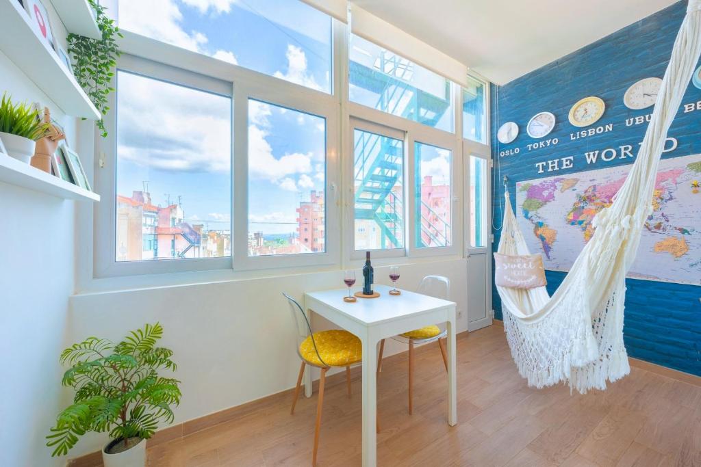 リスボンにあるWanderful Home - Travel Themed Apartmentのテーブルと椅子、窓が備わる客室です。