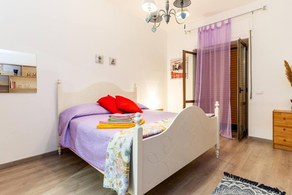 a bedroom with a bed with purple sheets and red pillows at GuestHouse Pet's Friendly in Quattromiglia