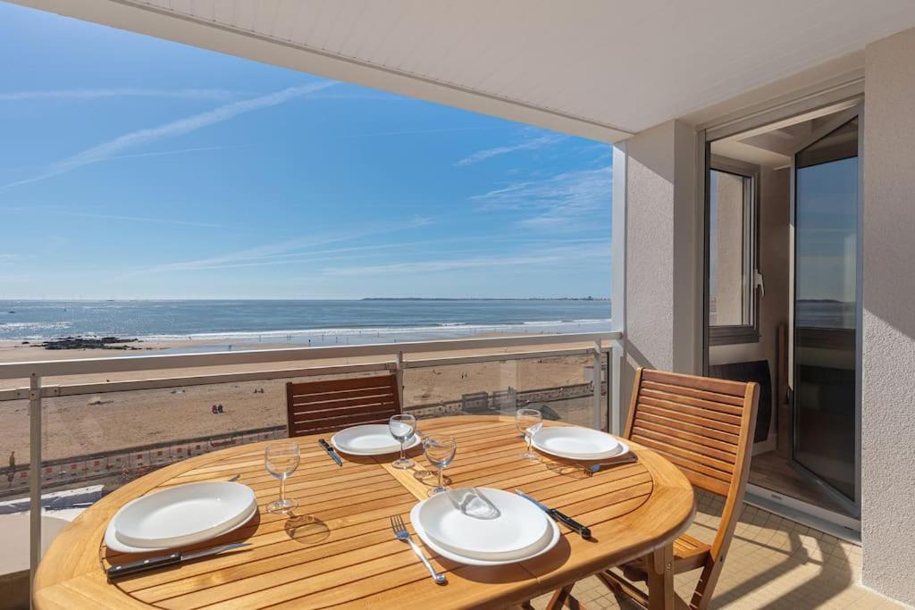 - une table en bois sur un balcon avec vue sur la plage dans l'établissement Appt spacieux FACE MER - 2 chambres - 6 personnes, à Pornichet