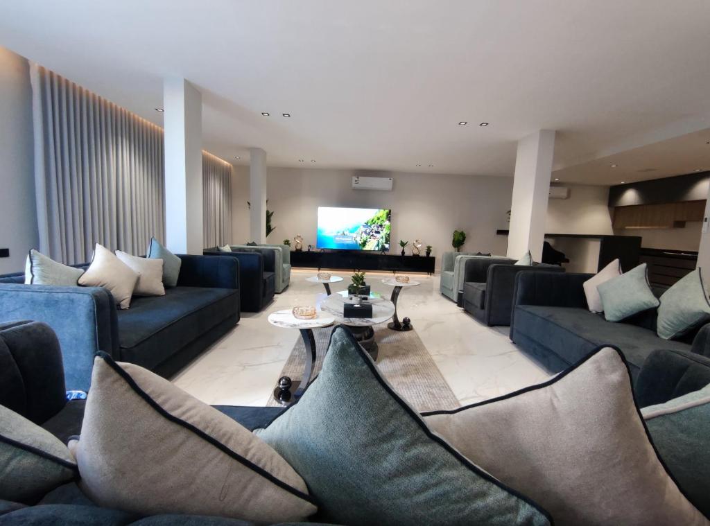 uma sala de estar com sofás azuis e uma televisão em فلل لافيندا الفندقية em Riade