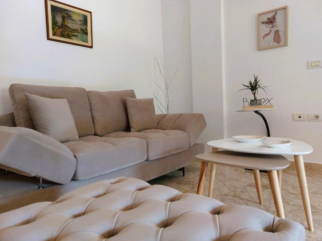 een woonkamer met een bank en een tafel bij Wendy's Apartment in Berat