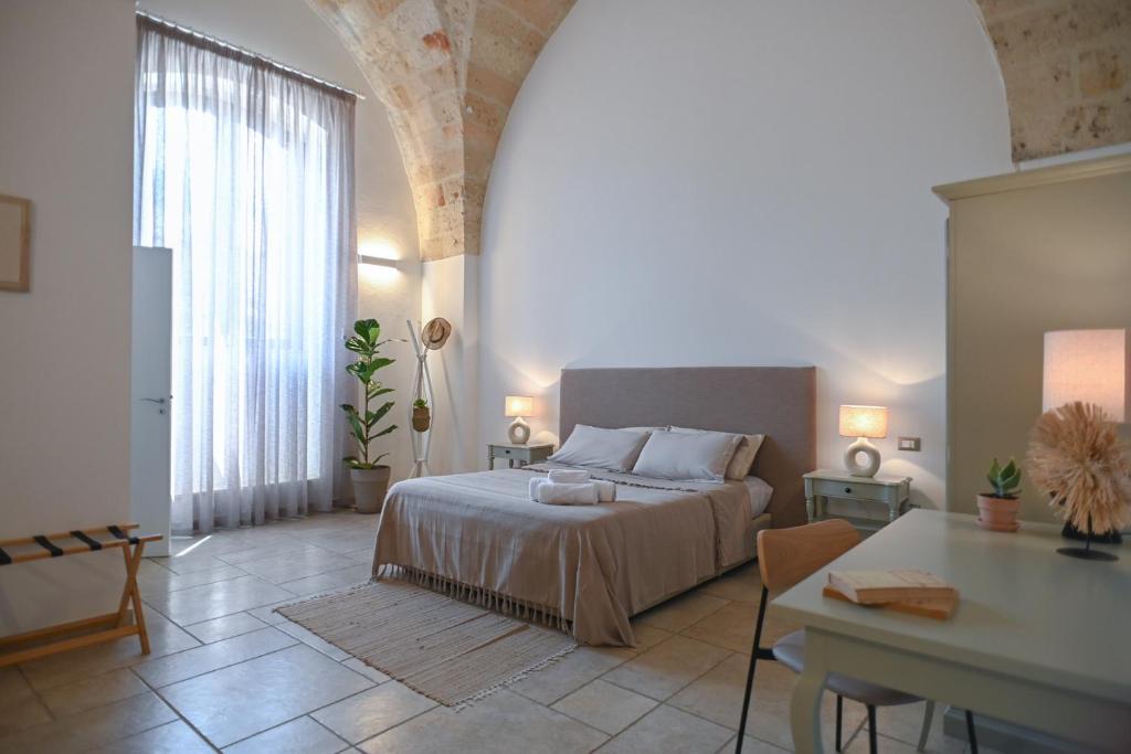 Un dormitorio con una cama y una mesa. en Mediterranea Residence, en Nardò