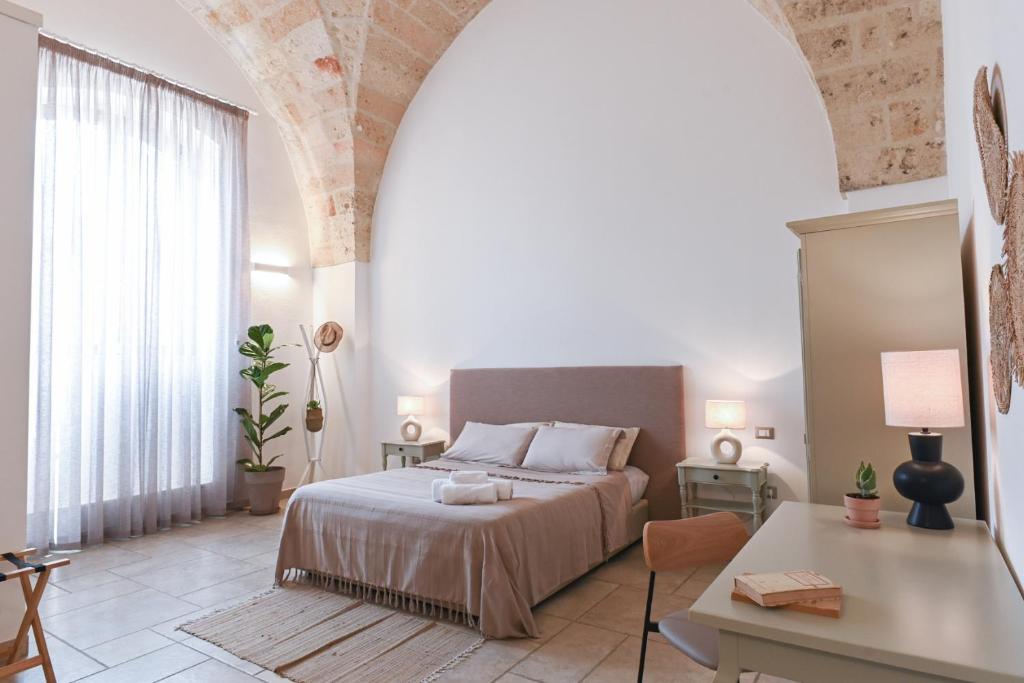 Mediterranea Residence في ناردو: غرفة نوم بسرير وطاولة ومكتب