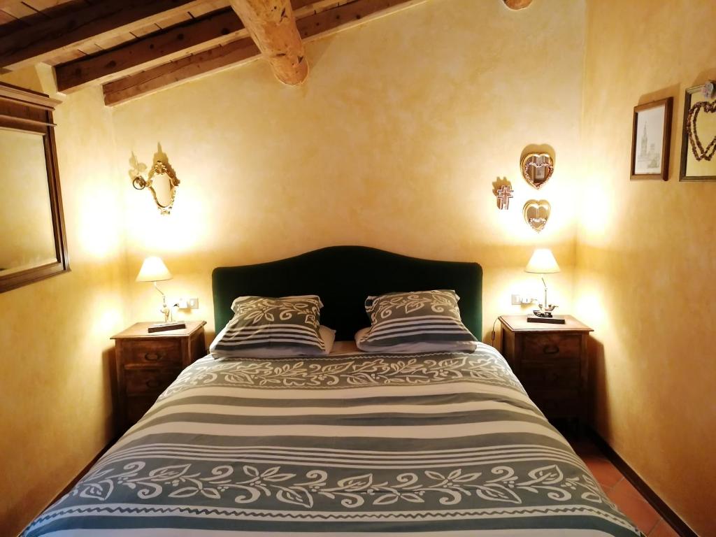 um quarto com uma cama grande e 2 mesas de cabeceira em Mansarda Vista lago a Campodolcino em Campodolcino